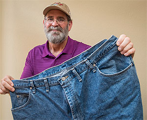 Jeff Mulvihill poses with a pair of pants he could barely fit into four months ago.