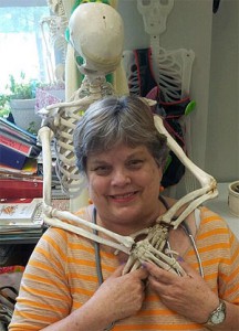 Horn Academy nurse Missy Bendiksen poses with "Mr. Bones," whom she keeps in her office to educate children about their bodies. Behind him hangs a tongue-in-cheek sign that reads, "This is what is left of the last child who didn't listen to the school nurse!"