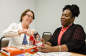 Dietitian Nan Cramer shows Senior Administrative Assistant Charlotte Blocker how to assess foods using the nutrition facts label.