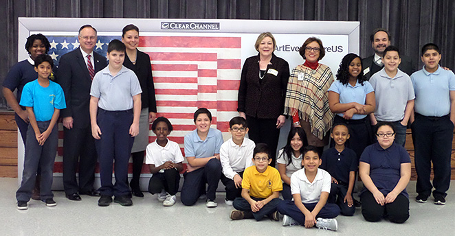 Students and staff at Cunningham ES pose in front of an Art Everywhere billboard featuring Three Flags, by artists Jasper Johns.